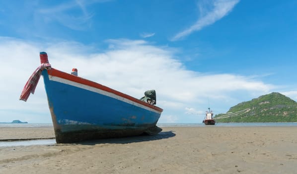 Blue fishing boat or fisherman boat or ship on Sam Roi Yod bech Prachuap Khiri Khan Thailand with blue sky and cloud and blue sea and .mountain or hill. Landscape or scenery for summer season concept