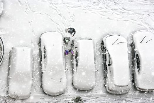 Elevated view of children play in snow covered parking lot