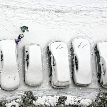 Elevated view of children play in snow covered parking lot