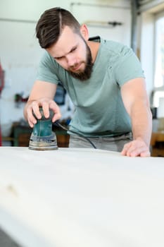 young worker with workpiece in a carpenter's workshop