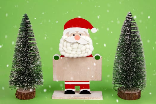 Decorative wooden Santa Clause holding a blank board as copyspace
