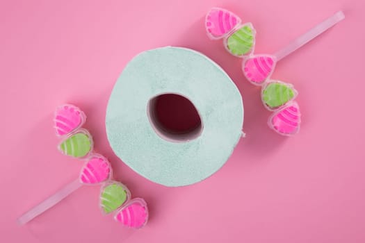 Sanitary Cleaner tablets with toilet paer on pink backround