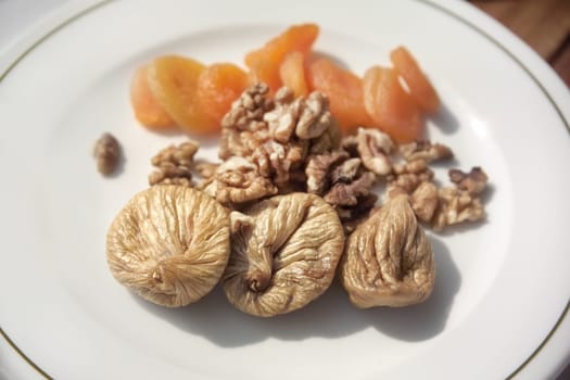 close up shot of dried fruits and walnut plate on breakfast table