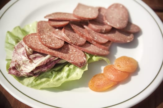 close up shot of sliced pepperoni plate on breakfast table
