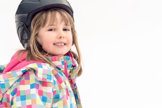 Winter portrait of a little girl wearing ski helmet during skiing lesson