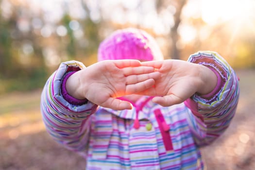 Portrait of young caucasian girl holding her in front of her face in a gesture suggesting to leave her alone