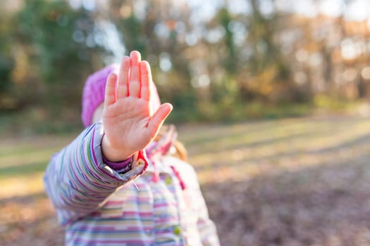 Portrait of young caucasian girl showing stop hand sign in front of her face