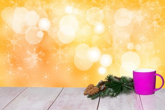 Christmas background. Table top christmas winter decoration background with an cup of tea and xmas tree fir branches over beautiful abstract yellow christmas background. Space for design. Card concept.