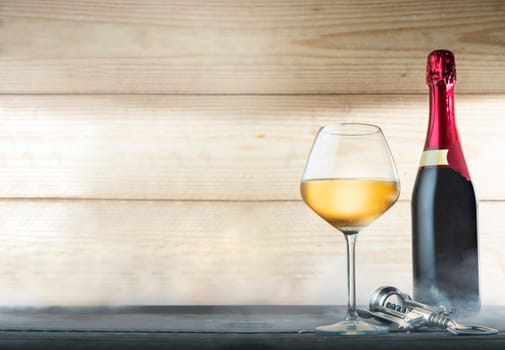 Wine bottle, glasses and corkscrew over wooden background
