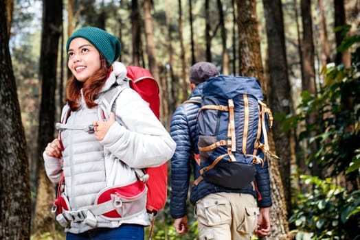 Smiling asian hikers woman exploring with hikers man in the forest