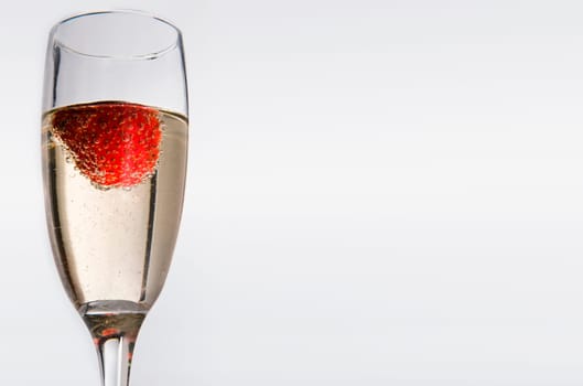 Glasses with white wine and strawberry isolated over white background