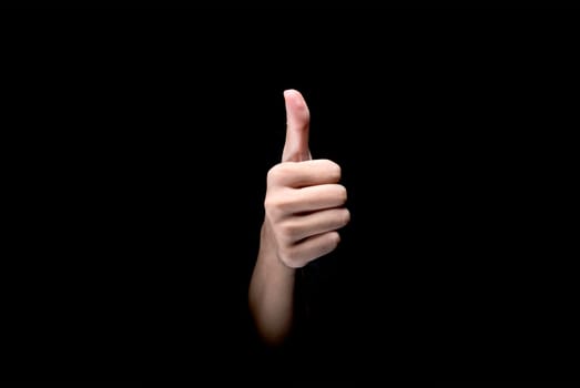 Male hands showing thumbs up gesture over dark background