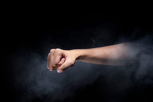 Male hands with fist gesture over dark background