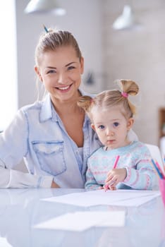 Little girl with crayon and her mother looking at camera