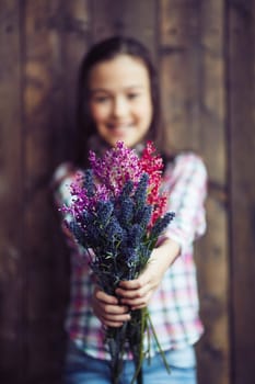 Little girl showing bunch of fresh wildflowers