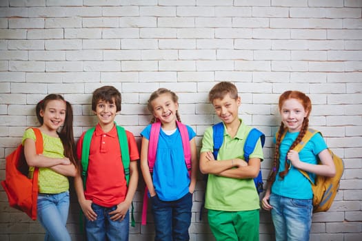 Group of cute school friends in casualwear looking at camera