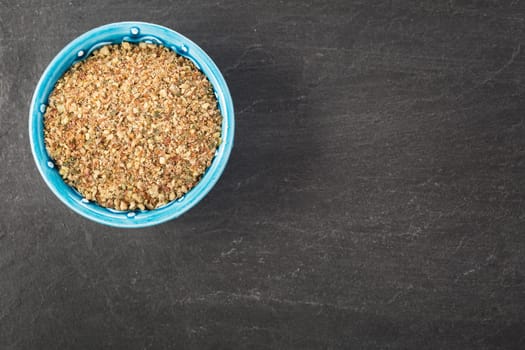 Bowl of healthy ground nut mix on stone surface with copy space