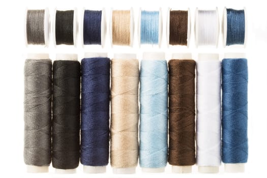 Colorful bobbins and spools of threads isolated on white