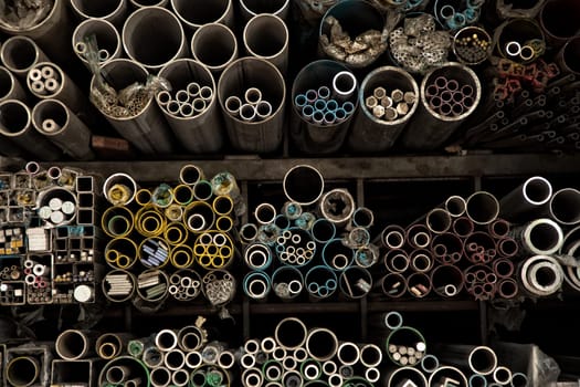 Close up various shape industrial steel products of metal profiles and tubes on warehouse shelf