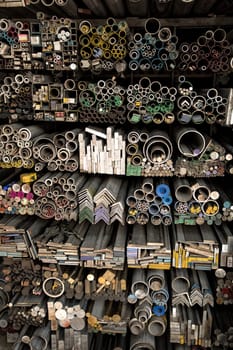 Close up various shape industrial steel products of metal profiles and tubes on warehouse shelf