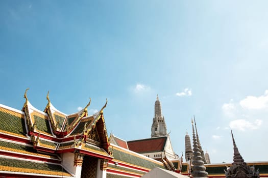 Architectural detail from exterior view of the Buddhist temple, Wat Arun over blue sky in Bangkok, Thailand