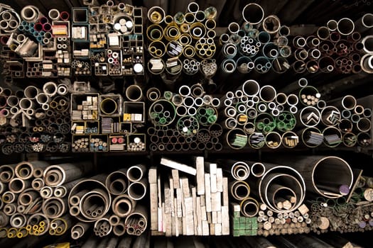 Close up various shape industrial steel products of metal profiles and tubes on warehouse shelf