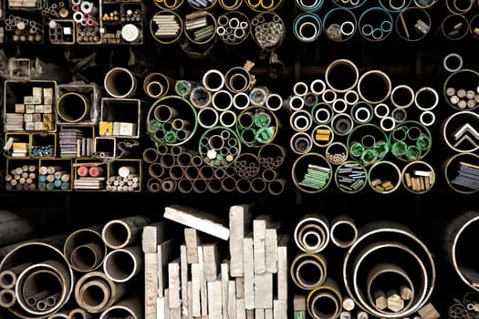 Close up various shape industrial steel products of metal profiles and tubes on warehouse shelf