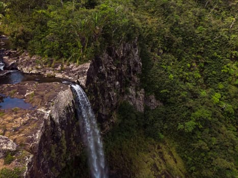 Aerial top view perspective of amazing 500 feet tall annamed waterfall in the tropical island jungle of Mauritius island.
