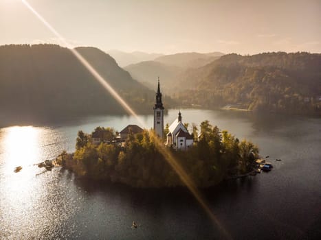 Aerial view of island of lake Bled with Pilgrimage Church of the Assumption of Maria in city of Bled in Slovenia at sunset.
