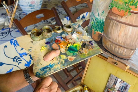 A wood palette full of oil paint colors