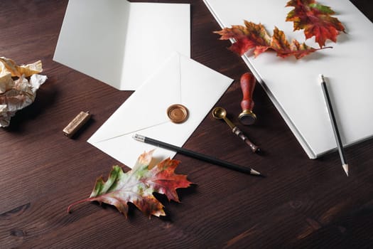 Vintage stationery template and autumn leaves on wood table background. Responsive design mockup.
