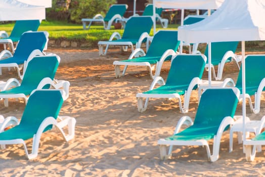 Beach in Turkey with sand in foreground, white sun shade umbrellas and chairs in background