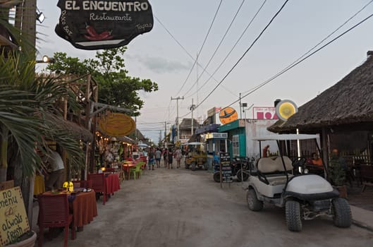sandy road with tourists and stalls on holbox island, quintana roo, mexico located in north yucatan peninsula