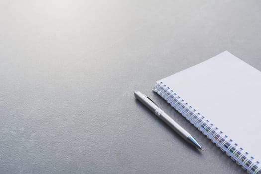 White blank notebook, textbook and pen on table with copy space.