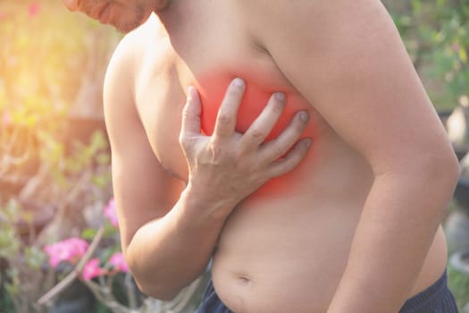 Man suffering from chest pain. Acute pain in a man muscle concept with red spot.