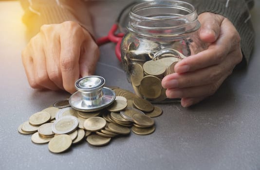 Stethoscope with Coins in jar with money stack, Concept finance, accounting, business and saving investment.