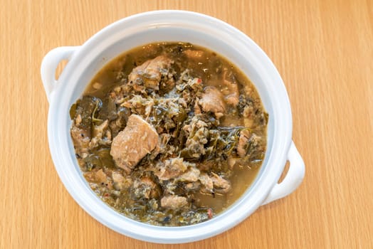 Thai Chamuang pork soup, pork with cowa leaf, thai east traditional food cuisine in white bowl on wooden background