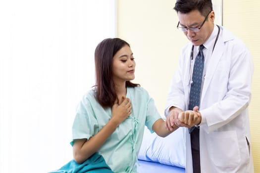 Asian Doctor make routine health check with patient in hospital ward