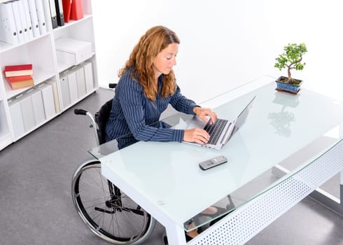 disabled businesswoman in wheelchair working  in the office