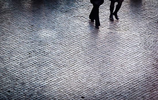 People walking on a cobblestones path. Texture effect