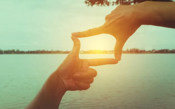 Close up of hands making frame gesture. Close up of woman hands making frame gesture with sunset.