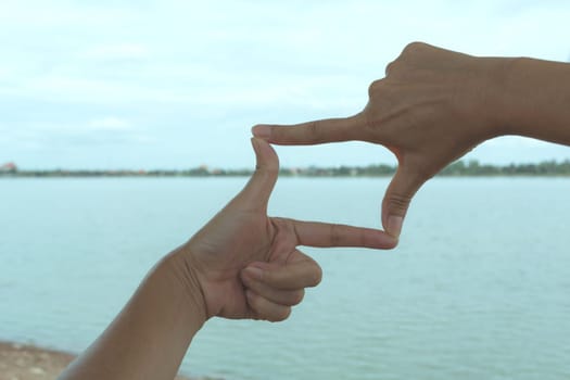 Close up of hands making frame gesture. Close up of woman hands making frame gesture with sunset.