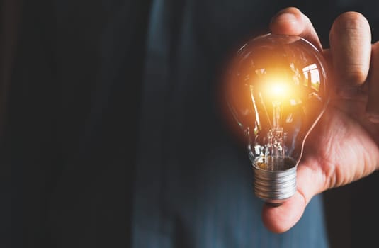 Hand of male holding a light bulb for innovation and creative concept .