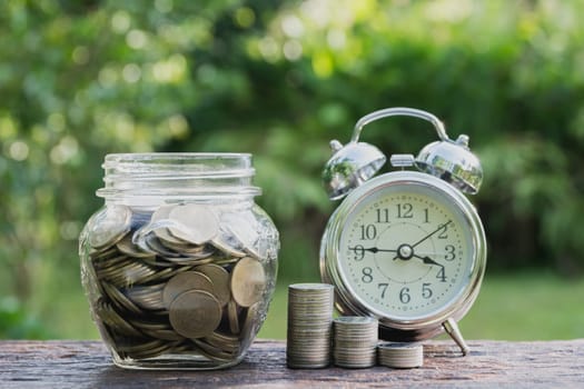 Saving money concept with money coin stack growing and alarm clock for business. financial and accounting concept.