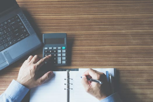 Businessman working and writing on notebook for business and accounting concept.