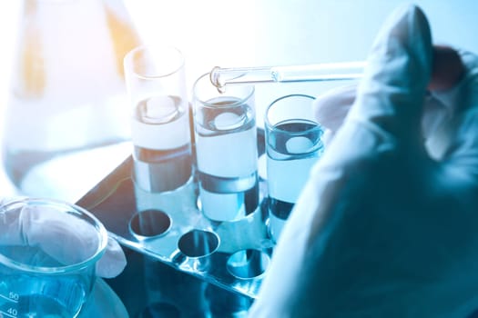 Researcher with glass laboratory chemical test tubes with liquid for analytical , medical, pharmaceutical and scientific research concept.