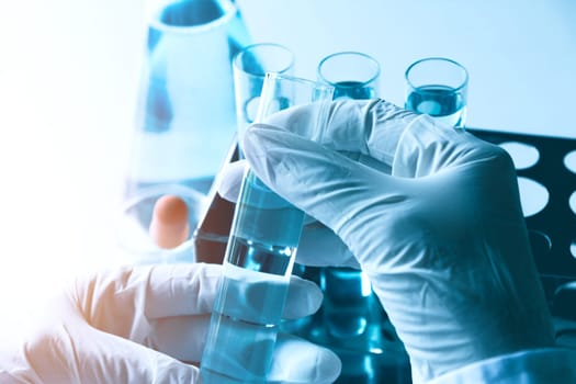 Researcher with glass laboratory chemical test tubes with liquid for analytical , medical, pharmaceutical and scientific research concept.