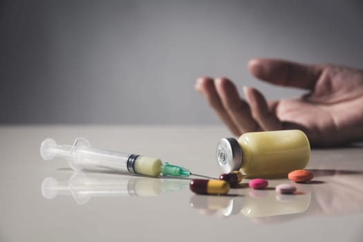 The man committing suicide by overdosing on medication. Close up of overdose pills and addict.