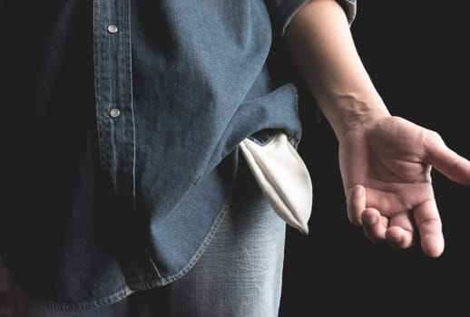 Man showing has no money by turning out the pocket. Empty pocket.