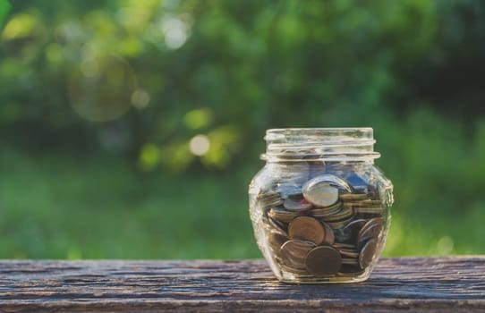 Saving money concept with money coin in glass jar for financial and accounting.